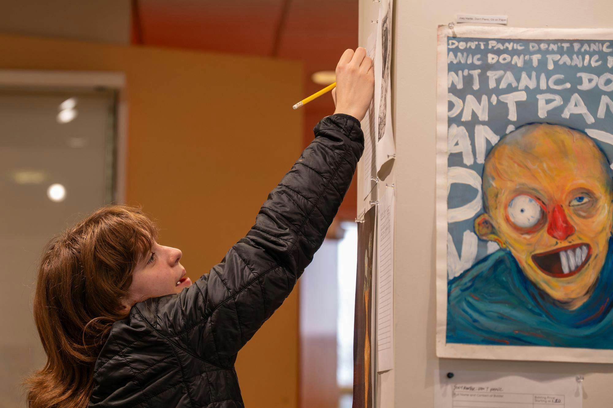 Ball State student bids on an artwork during the Art of Caring art show April 10 in the Art and Journalism Building. Kadin Bright, DN