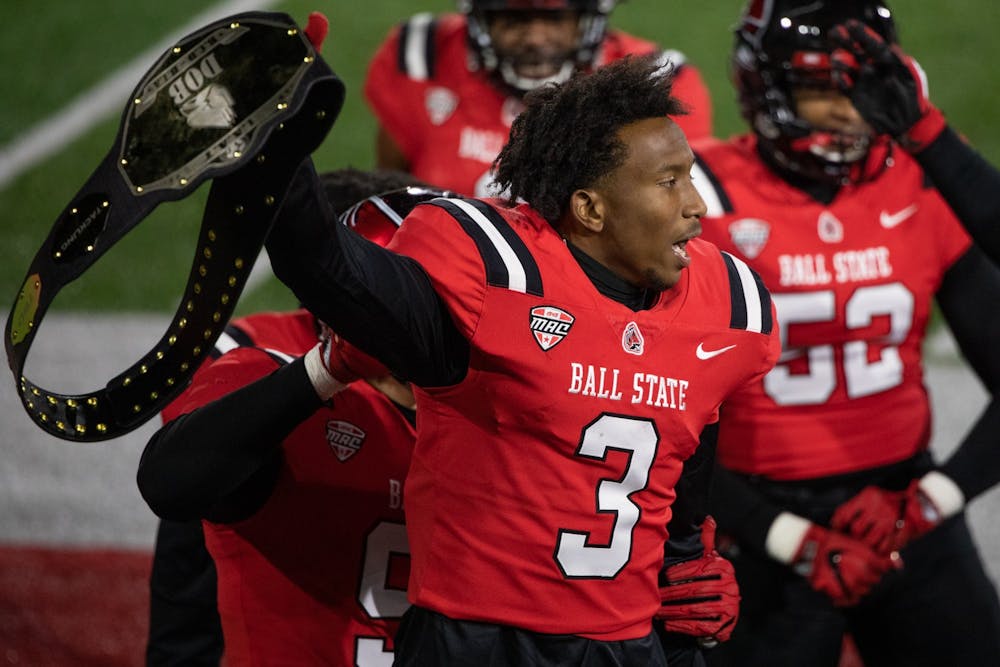 Ball State junior cornerback Amechi Uzodinma II holds up the defence celebration wrestling belt Nov. 18, 2020, at Scheumann Stadium. Uzodinma had one interception against the Huskies. Jacob Musselman, DN