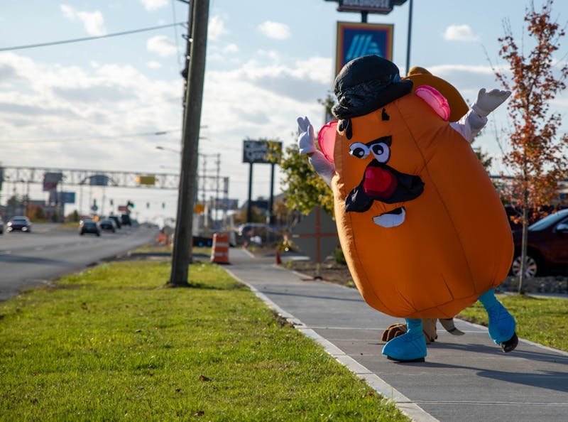 Matthew Peiffer, dressed in a Mr. Potato Head costume, dances on the sidewalk Oct. 16, 2020, outside Texas Roadhouse in Muncie. Peiffer started dressing up in various costumes to bring happiness to children. Jaden Whiteman, DN