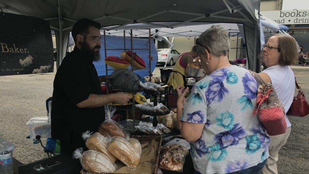 Shane Heath shows his bread options to customers Saturday, Sept. 8, 2018 in Muncie, IN. Heath, known as the Bearded Baker, made his goods 24 hours before the event to "ensure freshness." Trevor Weldy, DN