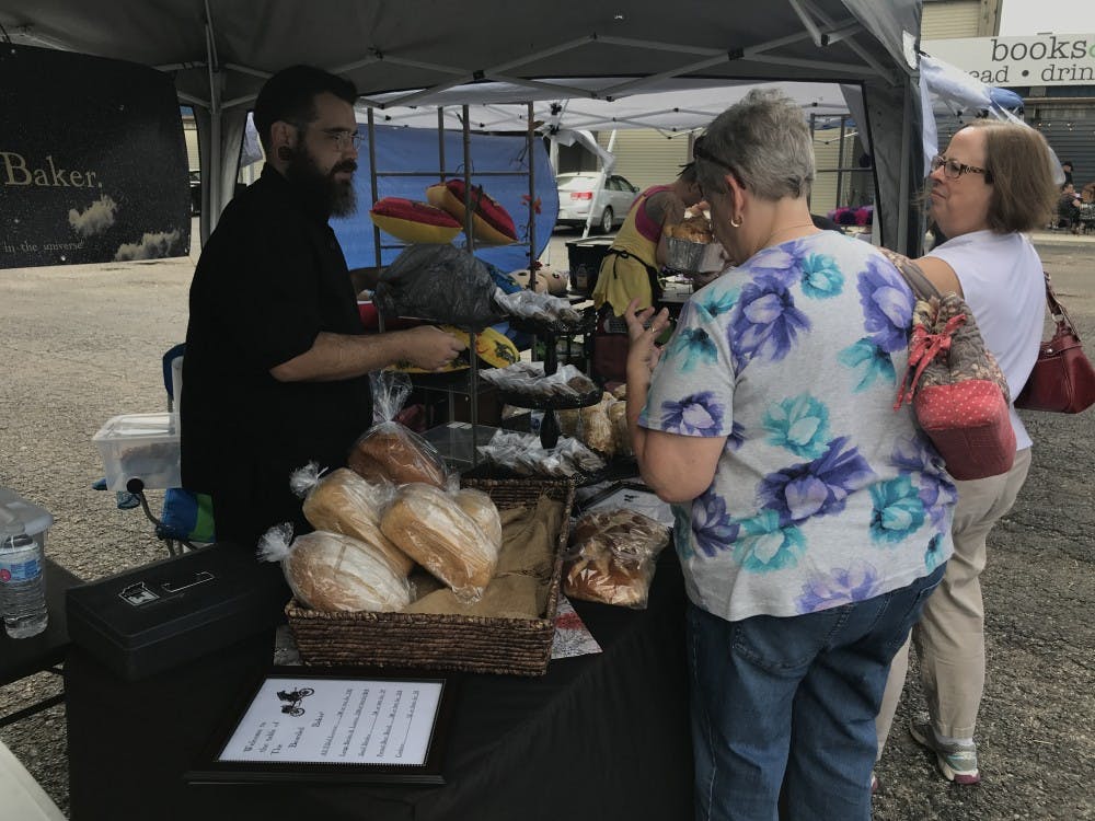Shane Heath shows his bread options to customers Saturday, Sept. 8, 2018 in Muncie, IN. Heath, known as the Bearded Baker, made his goods 24 hours before the event to "ensure freshness." Trevor Weldy, DN