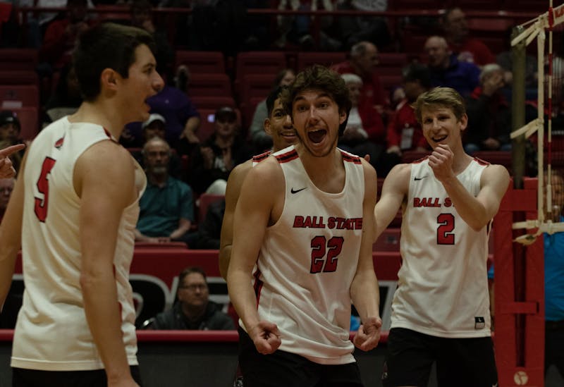 Graduate student Quinn Isaacson, senior Nick Martinski and senior Kaleb Jennes celebrate a point in the game against McKendree in Worthen Arena March 31. Ball State won all three sets. Jamie Howell, DN