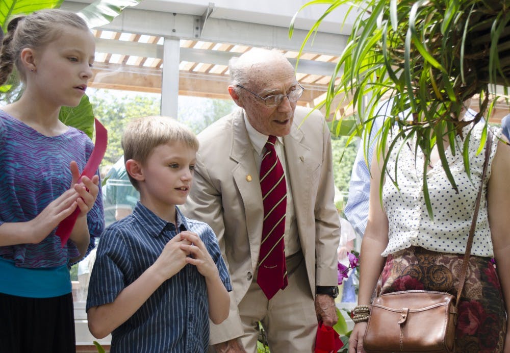Mary Federwsch, 11,  Jack Federwsch, 7, and Dr. Joe Rinard look at orchids on May 31 at the Dr. Joe and Alice Rinard Orchid Greenhouse. DN PHOTO BREANNA DAUGHERTY 