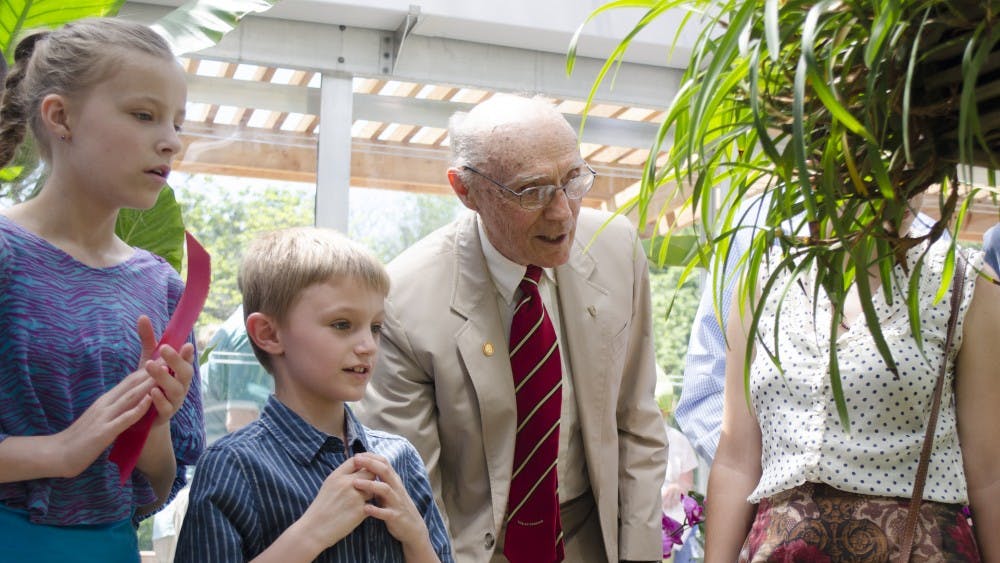 Mary Federwsch, 11,  Jack Federwsch, 7, and Dr. Joe Rinard look at orchids on May 31 at the Dr. Joe and Alice Rinard Orchid Greenhouse. DN PHOTO BREANNA DAUGHERTY 