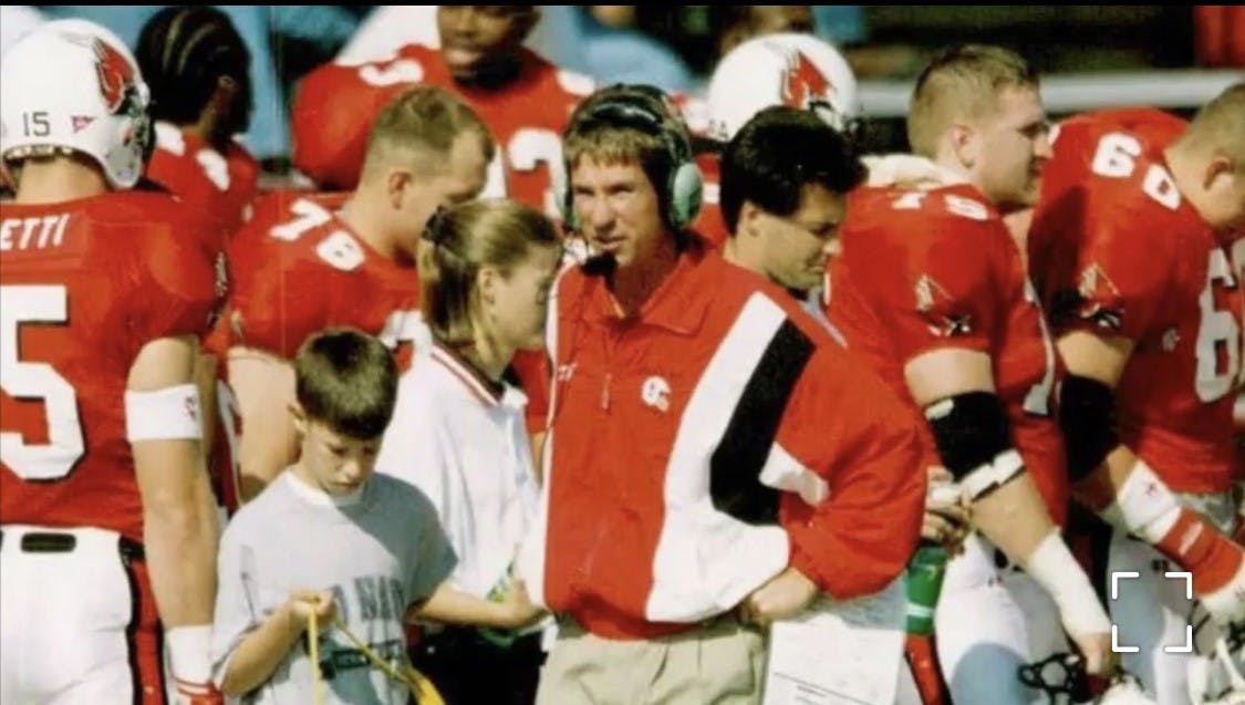 Now-Ball State offensive coordinator Kevin Lynch assists his father, Bill, in carrying cords on the Scheumann Stadium sidelines. Bill Lynch became the Cardinals&#x27; offensive coordinator in 1990 — a position Kevin now holds. Kelly Manor, photo provided. 