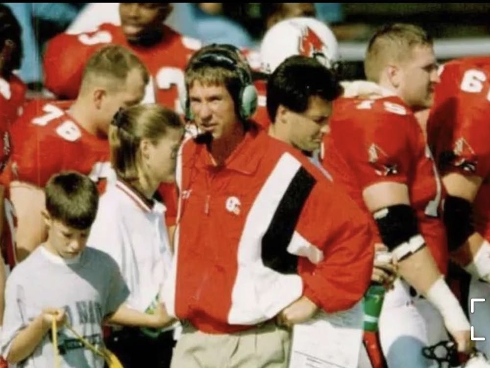 Now-Ball State offensive coordinator Kevin Lynch assists his father, Bill, in carrying cords on the Scheumann Stadium sidelines. Bill Lynch became the Cardinals&#x27; offensive coordinator in 1990 — a position Kevin now holds. Kelly Manor, photo provided. 