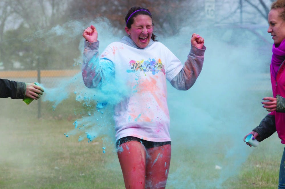 A runner reacts to getting hit with a colored substance during the Chase the Rainbow 5K race. DN PHOTO TAYLOR IRBY