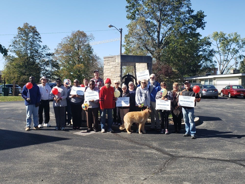 Participants hold up signs before participating in the walk. On Oct. 13 Christian Ministries held a hunger walk to help raise funds for their food pantry. Jaden Hasse, DN.