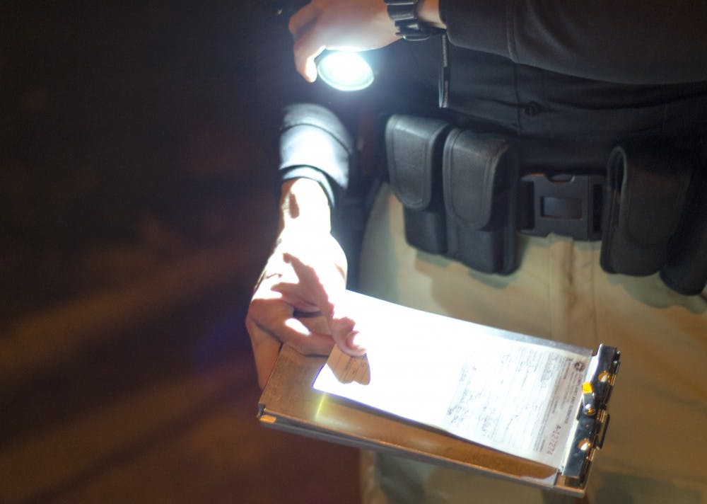 Indiana State Excise officer Brandon Thomas writes a minor consumption ticket to an underage student on Nov. 3, 2013.  Police are trying to reduce the amount of underage drinking with their Cops in Shops program. DN FILE PHOTO COREY OHLENKAMP