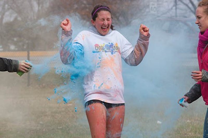 A participant in the Chase the Rainbow 5K emerge from clouds of neon paint during the race. Multiple stations throughout the course were set up and volunteers tossed color powder at runners as they went by. The 350 participants at the run on Saturday raised money for a Muscular Dystrophy Association summer camp. DN PHOTO TAYLOR IRBY
