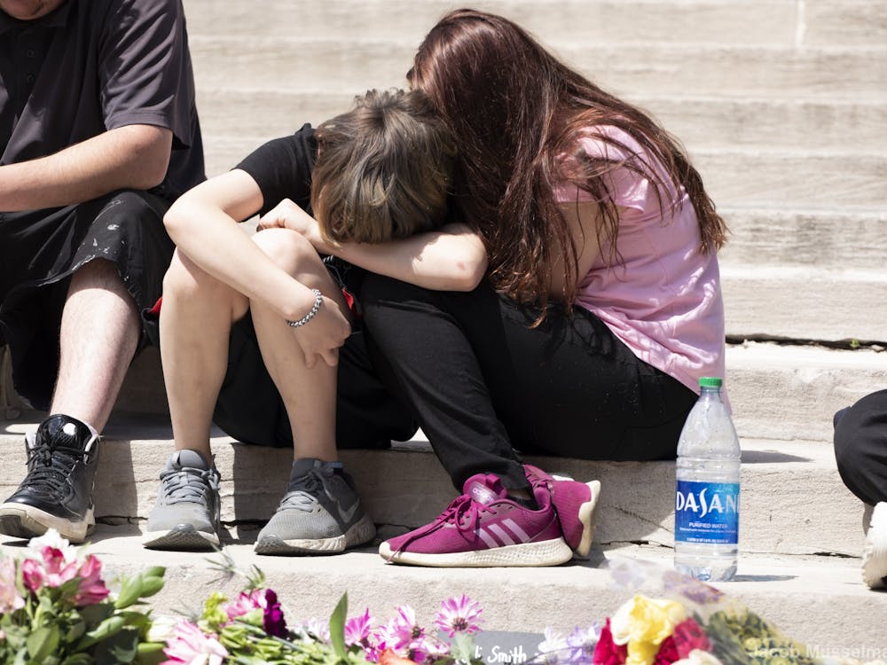 Two family members of one of the victims console one another April 18, 2021, at Monument Circle in Indianapolis. The vigil was held for the eight victims killed in the mass shooting at the FedEx hub in Indianapolis on April 15. Jacob Musselman, DN