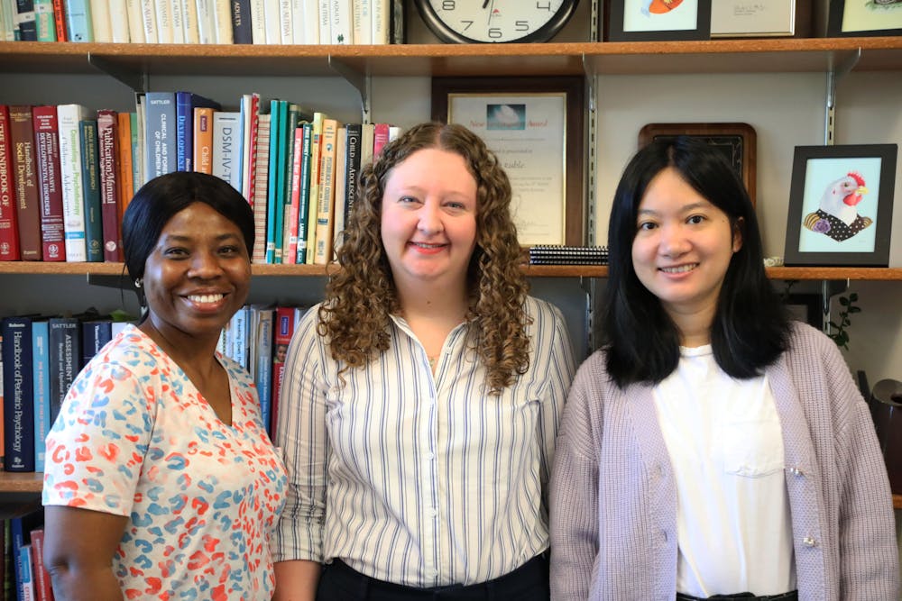 Graduate students (left and right) that work withAssistant professor of special education Lindsey Ogle (center) pose for a photo Oct. 3 in the Teachers College Building. Mya Cataline, DN