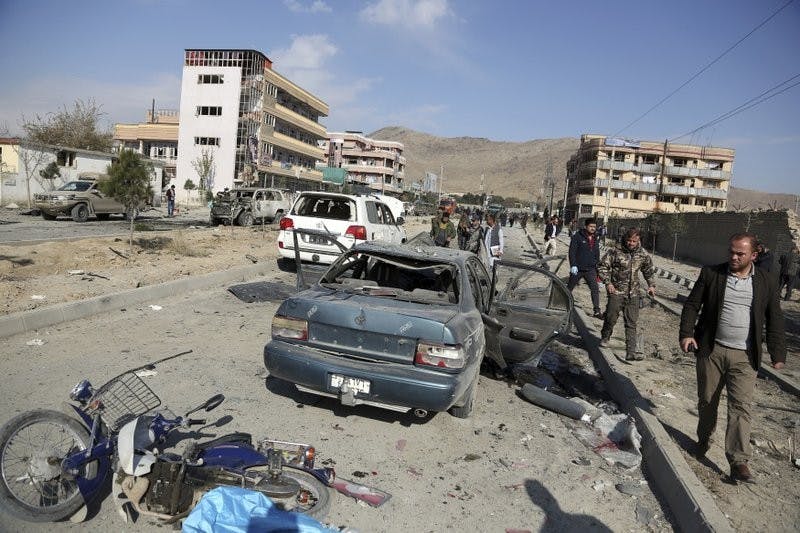 In this Nov. 13, 2019, file photo, Afghan security personnel gather at the site of a car bomb attack in Kabul, Afghanistan. Afghanistan will need vast amounts of foreign funding to keep its government afloat through 2024, a U.S. agency said Thursday, even as foreign donors are increasingly angry over the cost of debilitating corruption and the U.S. seeks a peace deal with Taliban to withdraw its troops. (AP Photo/Rahmat Gul, File)