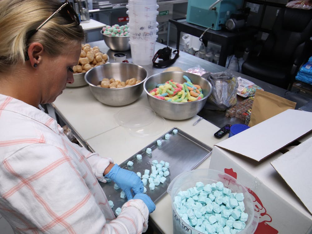 Mckensie Dishman, an employee of Fresh Market Treats, lays out pieces of saltwater taffy before placing them into the shop&#x27;s freeze dryer March 5, 2021. Rylan Capper DN 