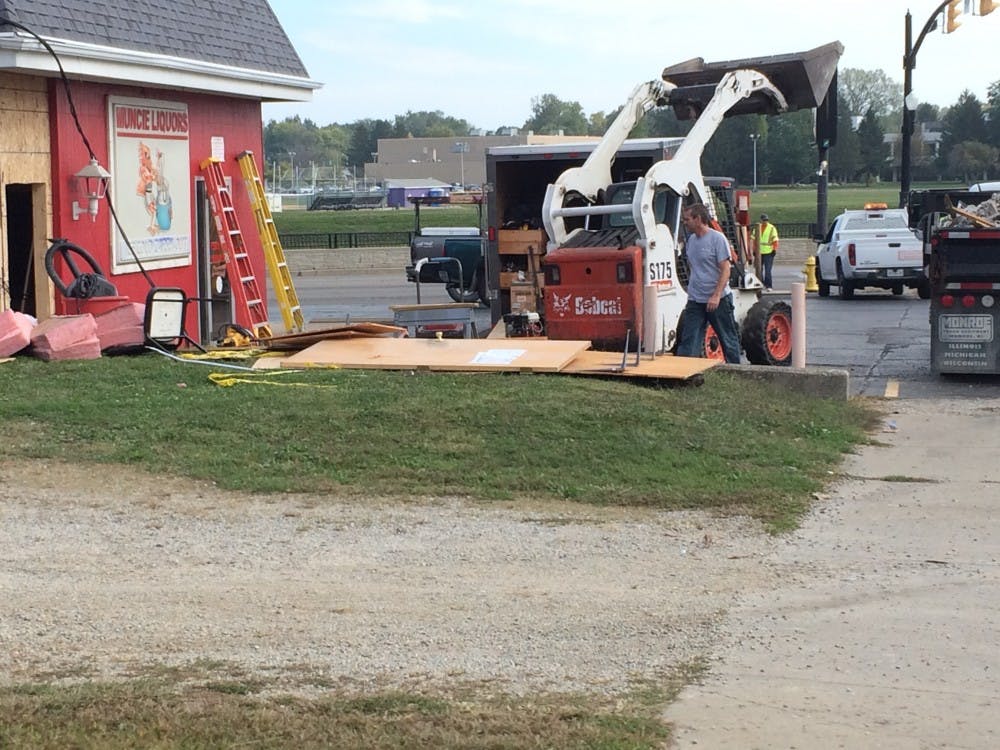 Crews clean up damage after a 19-year-old crashed into Muncie Liquors on Wheeling Avenue around 3:30 a.m. Sept. 27. DN PHOTO CHRISTOPHER STEPHENS
