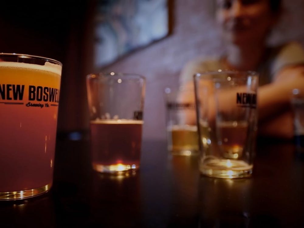 Three customers drink at New Boswell Brewery Company in Richmond, Ind., during the filming of