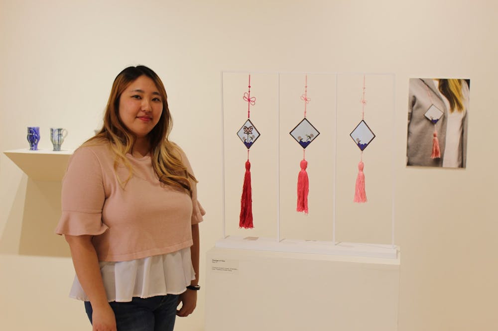 <p>Seul Yi in front of her work titled "Passage of Time." Her work is modeled after traditional Korean outfit tassels. The length of each resembles the passing of time. <strong>Chase Martin, DN</strong></p>