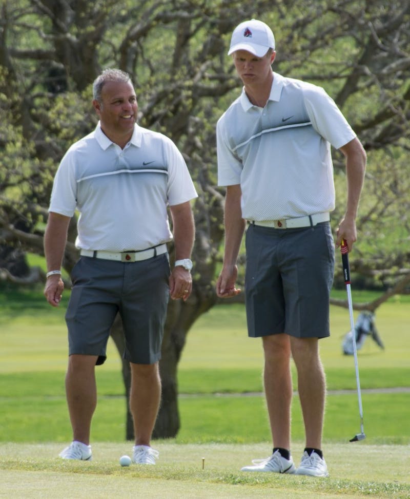Head coach Mike Fleck coaches Junior Michael Vandeventer at hole 11 during the Earl Yestingsmeier Memorial Invitational on April 14 at the Deleware Country Club. Last year Vandeventer had a 74.85 scoring average. Kaiti Sullivan // DN