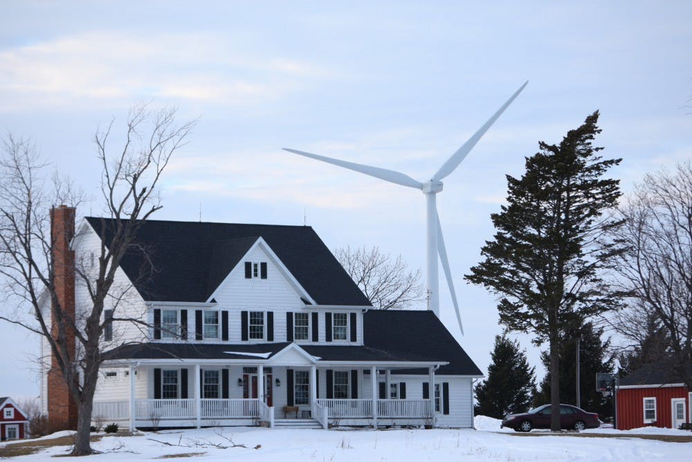 Wind turbines spin near a home on Feb. 17, 2010, in Shabbona, Ill. The turbines are required to be at least 1,400 feet from the foundation of nearby homes. MCT PHOTO