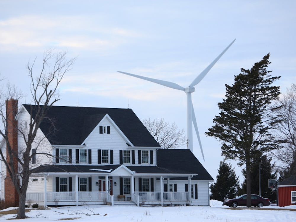 Wind turbines spin near a home on Feb. 17, 2010, in Shabbona, Ill. The turbines are required to be at least 1,400 feet from the foundation of nearby homes. MCT PHOTO