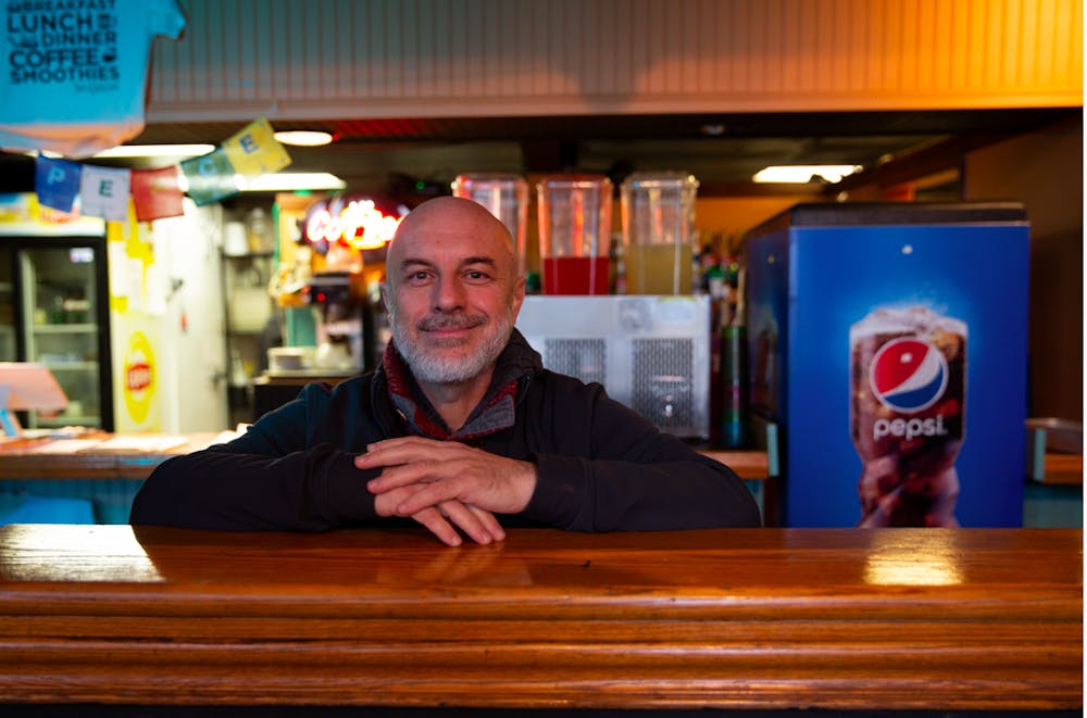 <p>Basam Helwani, the owner of Two Cats Cafe and Damask Cafe, stands in Two Cats Wednesday, Dec. 4. He is closing down his restaurants after accepting an offer to work for Pocket Points in California. <strong>Brynn Mechem, DN Photo</strong></p>