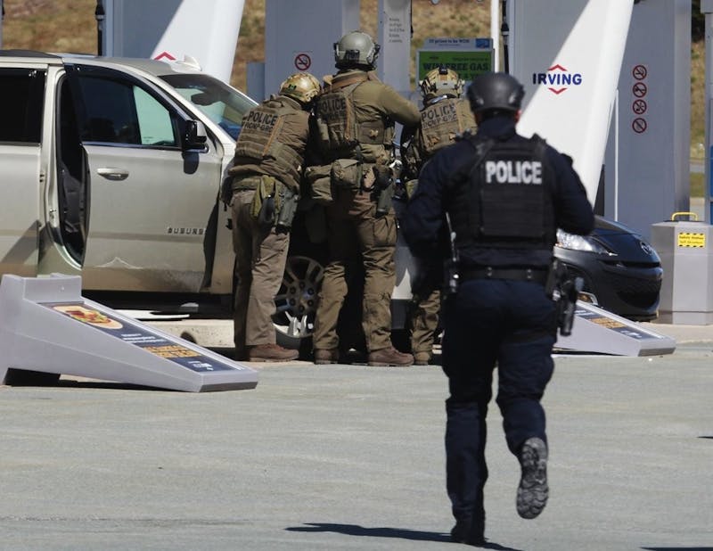 Royal Canadian Mounted Police officers surround a suspect at a gas station in Enfield, Nova Scotia on Sunday April 19, 2020. Canadian police say multiple people are dead plus the suspect after a shooting rampage across the province of Nova Scotia. (Tim Krochak/The Canadian Press via AP)