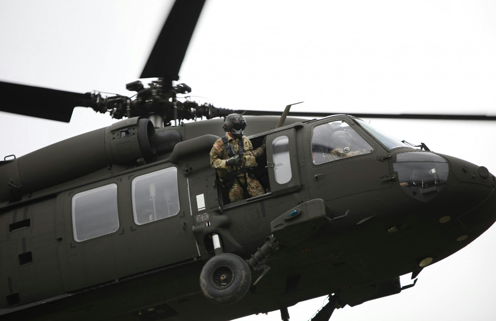 A U.S. Army soldier leans out of a helicopter as it lands March 24 near the Glick Center for Glass. 122 ROTC cadets from Ball State, Indiana Wesleyan and Purdue Fort Wayne will participate in training at Camp Atterbury over the weekend. Rylan Capper, DN 