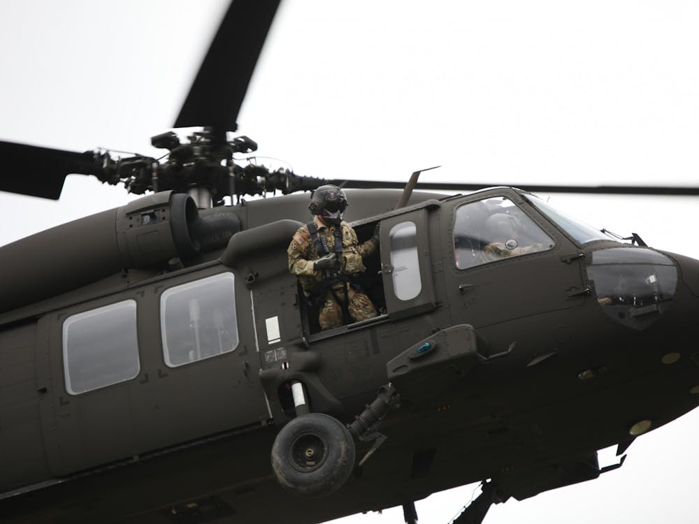 A U.S. Army soldier leans out of a helicopter as it lands March 24 near the Glick Center for Glass. 122 ROTC cadets from Ball State, Indiana Wesleyan and Purdue Fort Wayne will participate in training at Camp Atterbury over the weekend. Rylan Capper, DN 