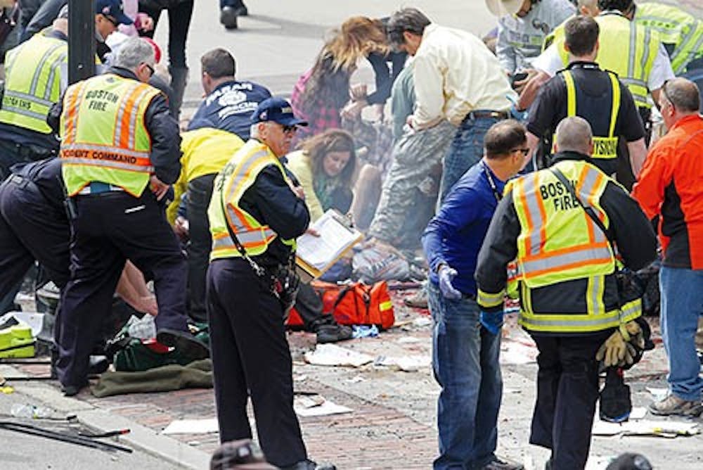 Emergency personnel assist the victims at the scene of a bomb blast during the Boston Marathon on Monday. MCT PHOTO