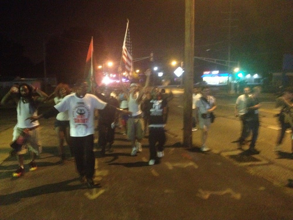 Ball State students capture peaceful protests in Ferguson, Mo. Members of the media walk in the streets, ignoring police orders to move back on to the sidewalk. PHOTO PROVIDED BY WES LORENZ