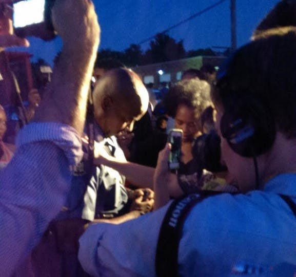 Police and protesters join in prayer Friday Aug. 22, 2014 for peaceful demonstrations and an end to rioting. WES LORENZ