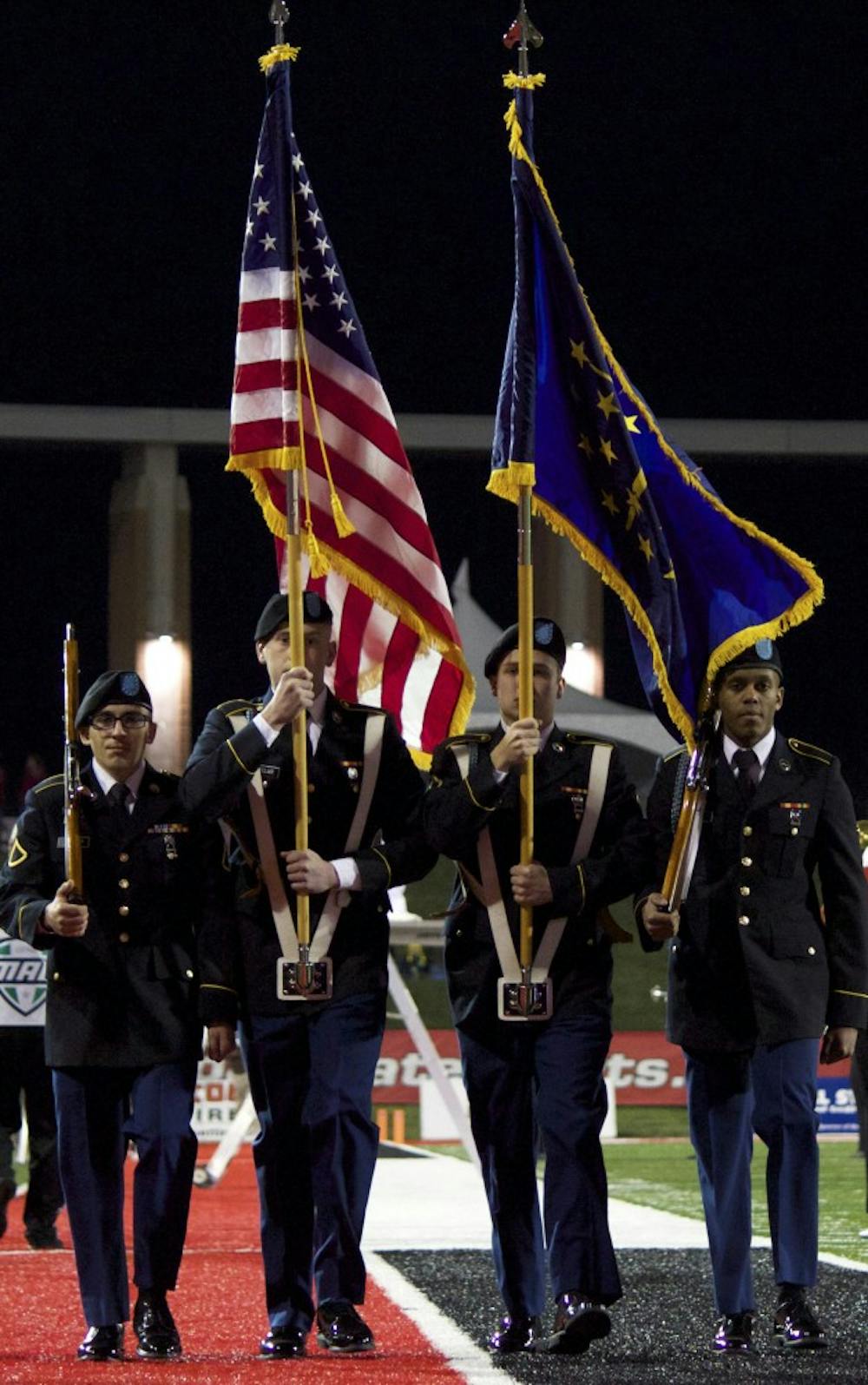 Members of the military lead the American flag off the field after the singing of the National Anthem before the game against Bowling Green on Nov. 24 in Scheumann Stadium. DN PHOTO GRACE RAMEY