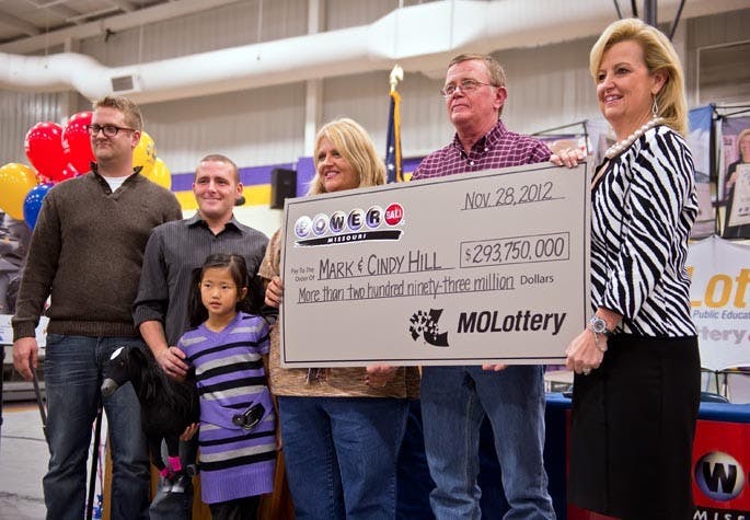 Cindy and Mark Hill, center and second from right, stand with a ceremonial check from the Missouri Lottery for $293,750,000 during the news conference, Friday, November 30, 2012, at North Platte High School in Dearborn, Missouri, after the family claimed $293,750,000 as co-winners in the Powerball lottery jackpot. At far left are sons Jarod and Cody Hill and daughter Jaiden Hill. At far right is May Scheve, director of the Missouri Lottery. (David Eulitt/Kansas City Star/MCT)