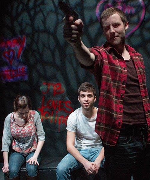 Billy, played by James Best, shows off his gun during a run of “Language of Angels” Monday night. Danielle, played by Ashley Greenwood, and Michael, played by Jake Milligan, react behind him. “Language of Angels” opens tonight in the Cave Theatre. DN PHOTO TAYLOR IRBY