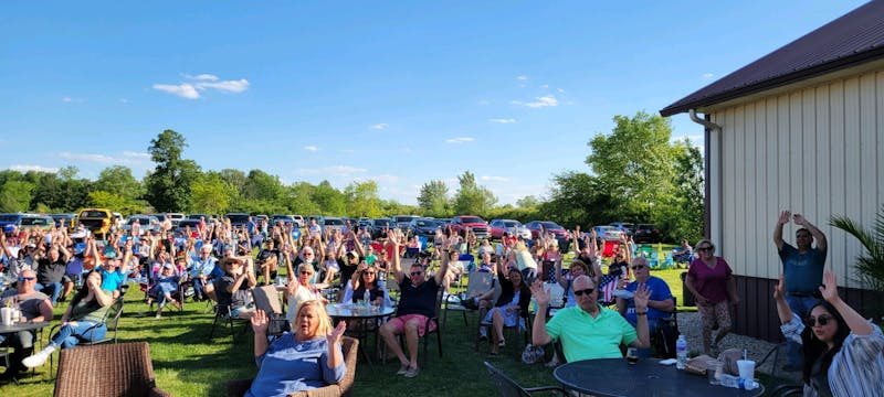 Attendees of Tonne Winery's Tonne Music Series celebrate their night in Muncie, Indiana in 2022. The Tonne Music Series is a weekly event that showcases local music, along with food trucks and products courtesy of the winery. (Sara Rogers)