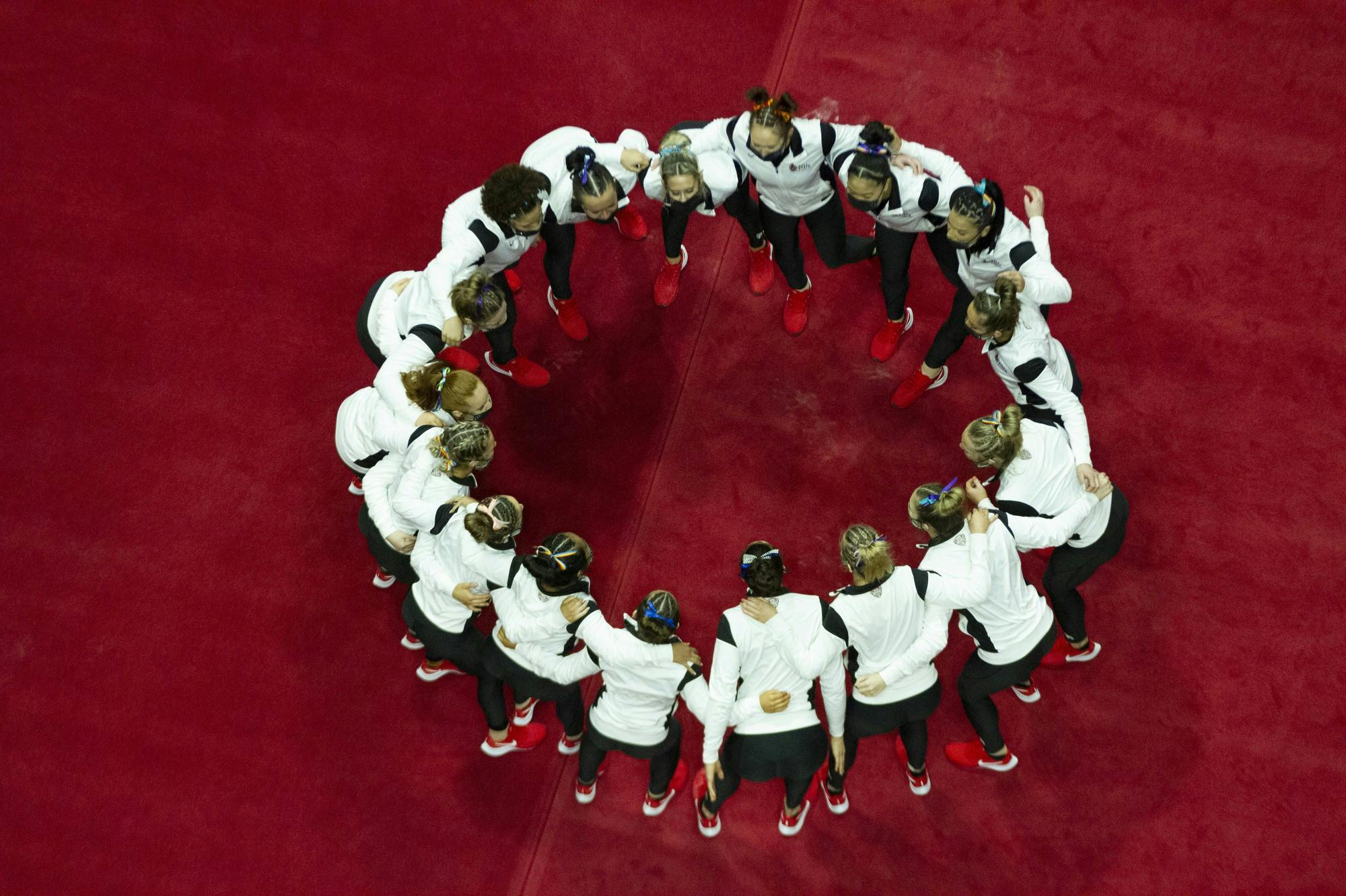 The gymnastics team huddles up for one last time as a team on Senior Day Feb. 28, 2021, at John E. Worthen Arena. The Cardinals lost their first meet this season in a 194.300-194.225 loss the the Western Michigan Broncos. Grace Walton, DN