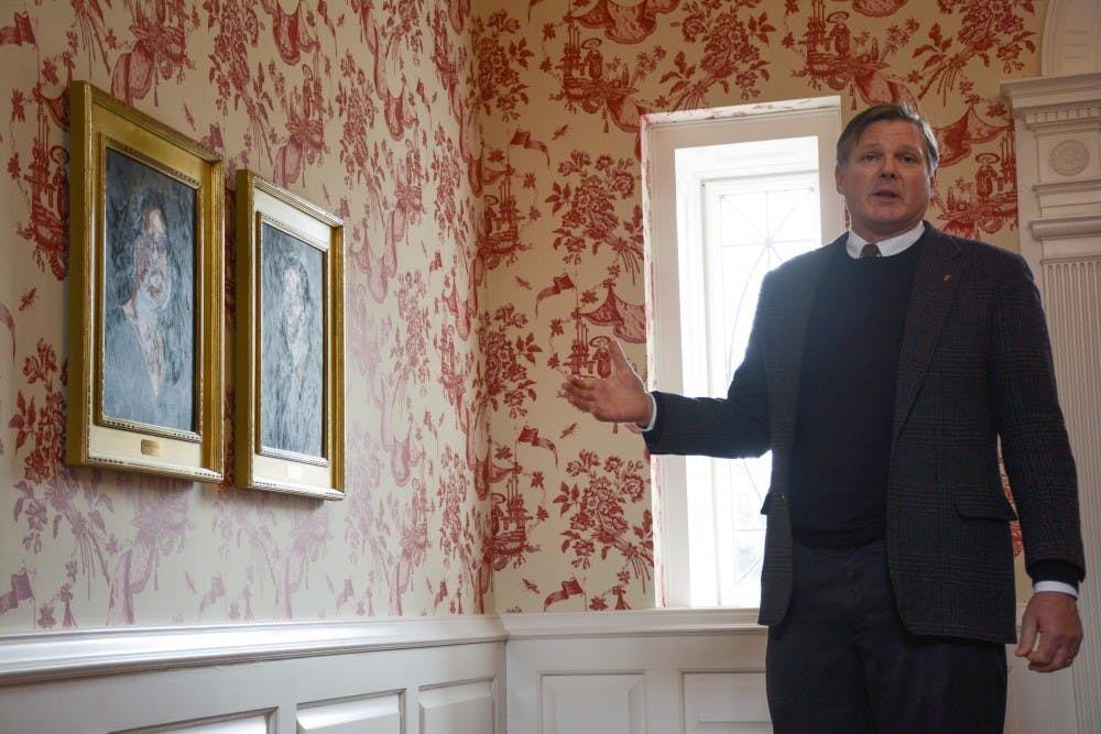 <p>Ball State Board of Trustees Secretary Tom Bracken gestures to two portraits of his grandparents that used to live in the Bracken House. Bracken said he will not be seeking a third term at the board. <strong>Kaiti Sullivan, DN File</strong></p>