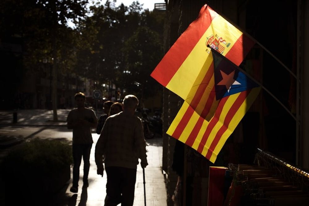 <p>People walk past a Spanish and an estelada, or independence flag, hanging up for sale in a shop in Barcelona, Spain, Wednesday, Oct. 11, 2017. The Spanish Cabinet met in Madrid Wednesday to work out its response to an announcement from the head of the wealthy Catalonia region that he was proceeding with a declaration of independence, further fueling Spain’s worst political crisis in decades. <strong>Emilio Morenatti, Associated Press Photo, Photo Courtesy&nbsp;</strong></p>