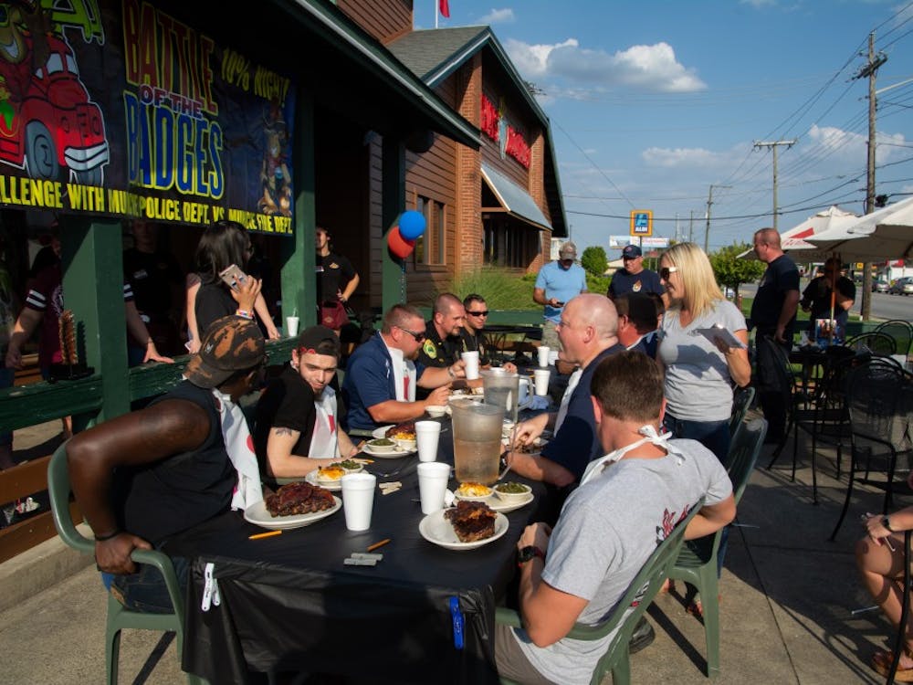Workers, friends and families gather to watch the Muncie Police Department (left) and Muncie Fire Department (right) compete in the fifth annual Battle of the Badges rib-eating contest Sept. 18, 2018, at Texas Roadhouse in Muncie. The winner of the contest won a monetary award which is donated to a charity of their choosing. Leslie Gartrell,DN