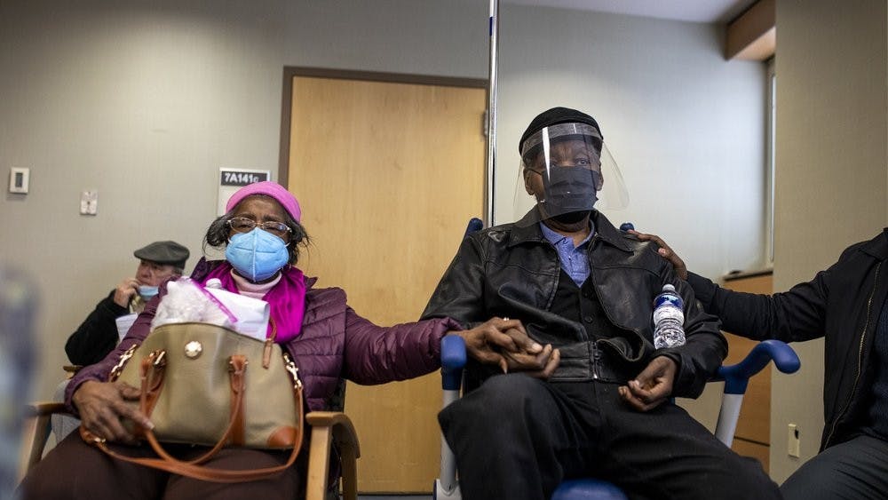 FILE - In this Jan. 23, 2021, file photo, Dorothy Kade, left, holds the hand of her husband, Walter Kade Jr., as they wait in the observation room after he received a COVID-19 vaccine at the VA Medical Center, in Philadelphia. (Tyger Williams/The Philadelphia Inquirer via AP, File)