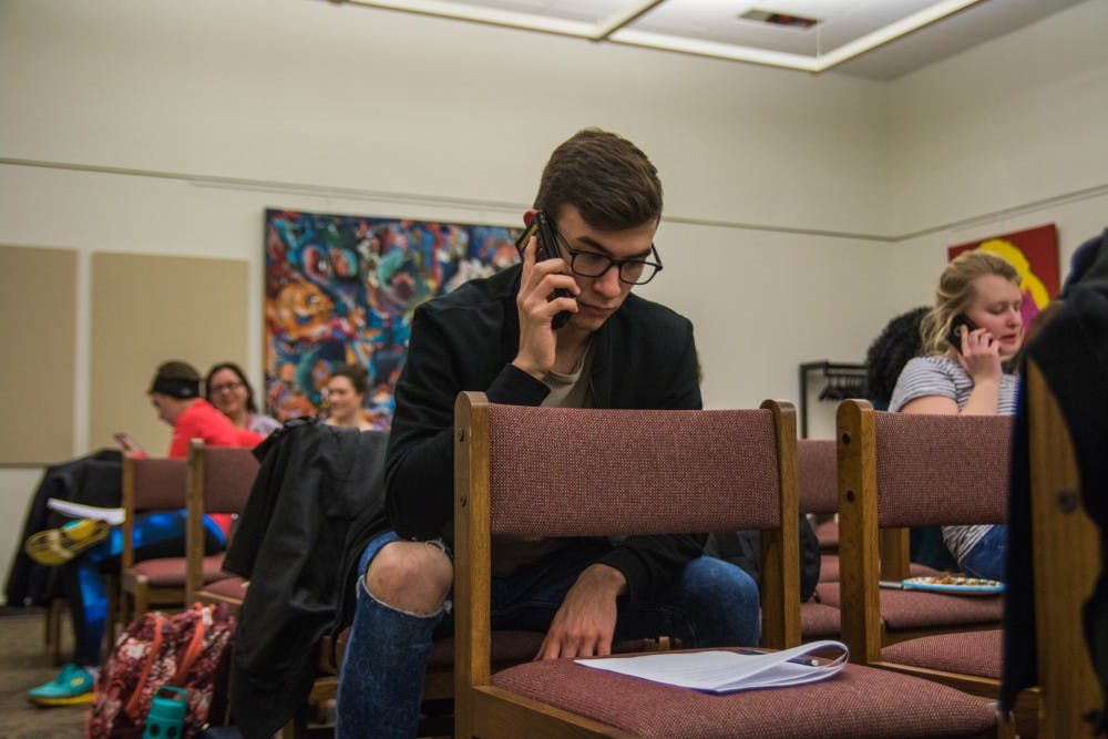 Ben Slightom, junior architecture and philosophy major, was one of many students gathered in Bracken Library on Jan. 30 to call U.S. and state senators and representatives, urging them to stop Indiana's SB 285, the Devos Confirmation, the ACA Repeal and to reject the Muslim ban. Reagan Allen // DN