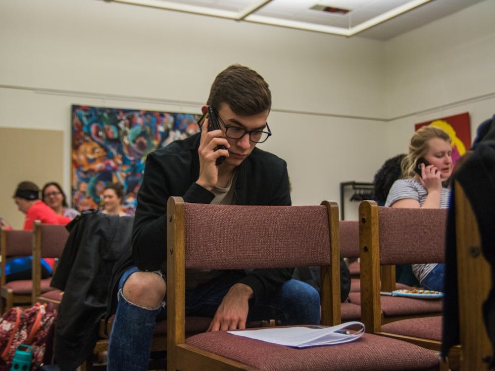 Ben Slightom, junior architecture and philosophy major, was one of many students gathered in Bracken Library on Jan. 30 to call U.S. and state senators and representatives, urging them to stop Indiana's SB 285, the Devos Confirmation, the ACA Repeal and to reject the Muslim ban. Reagan Allen // DN