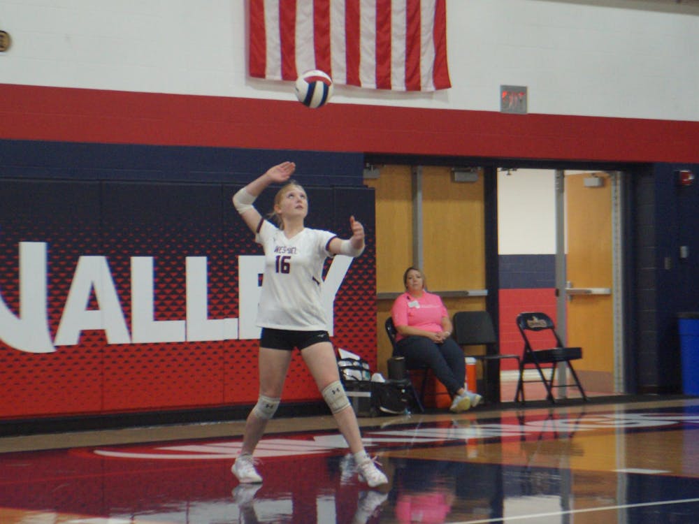 Freshman Lillian Byrd readies a serve to send flying into the opposing team. The Warriors will fight again Sept. 30, taking on the Eastbrook Panthers. SECOND PHOTO BY NICK ROARK