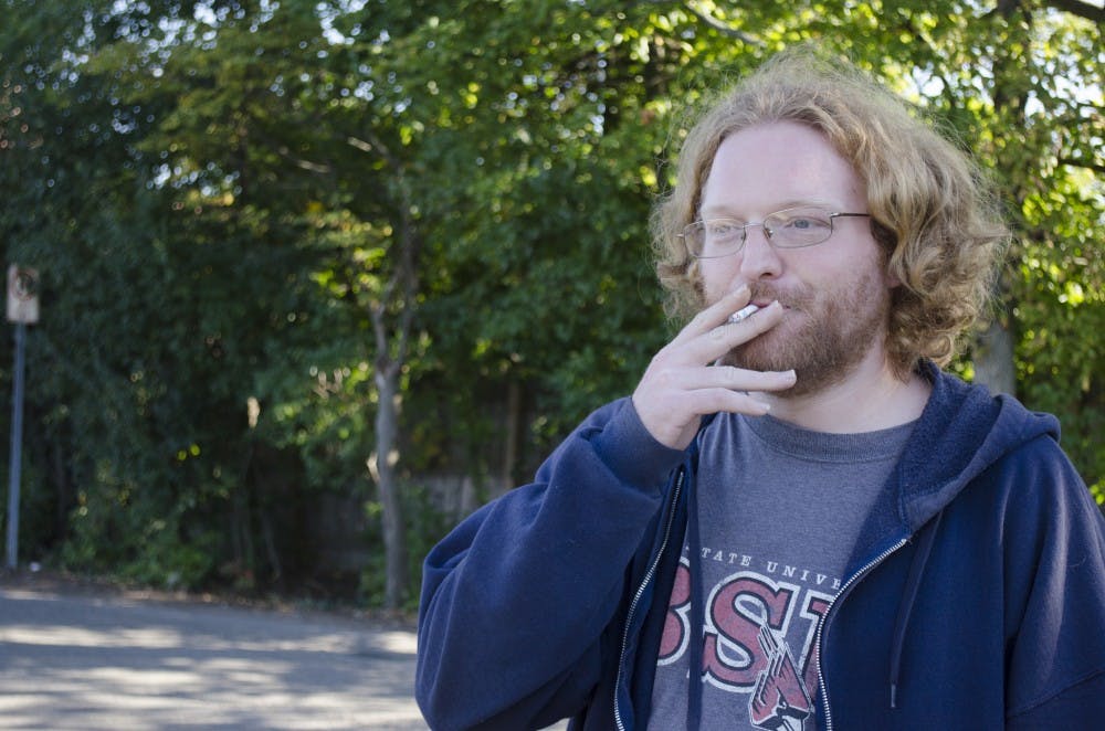 Brad Sharer, a graduate student, smokes a cigarette in between classes Oct. 14, 2013 on Petty Road, just off Ball State’s campus. In the smoking ban’s first year, the university issued 22 citations. DN FILE PHOTO BREANNA DAUGHERTY