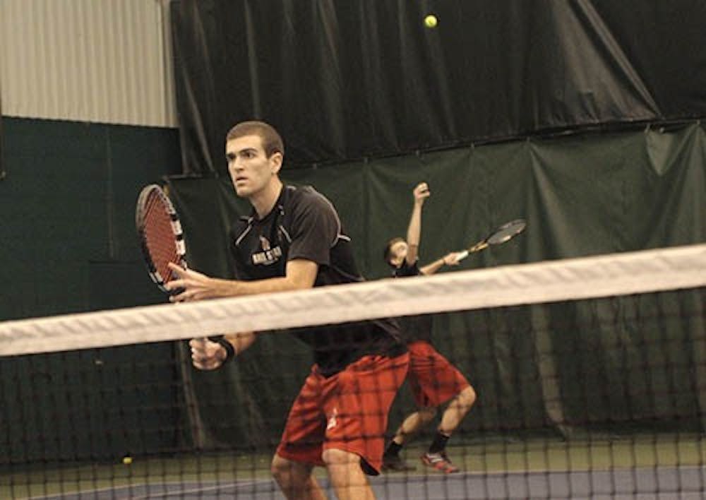 Patrick Elliot stands by while his partner Ray Leonard serves a ball to lead their first doubles set against Xavier on March 17. The team will take on Notre Dame at 1 p.m. today. FILE PHOTO PROVIDED BY ALISON MERCADO