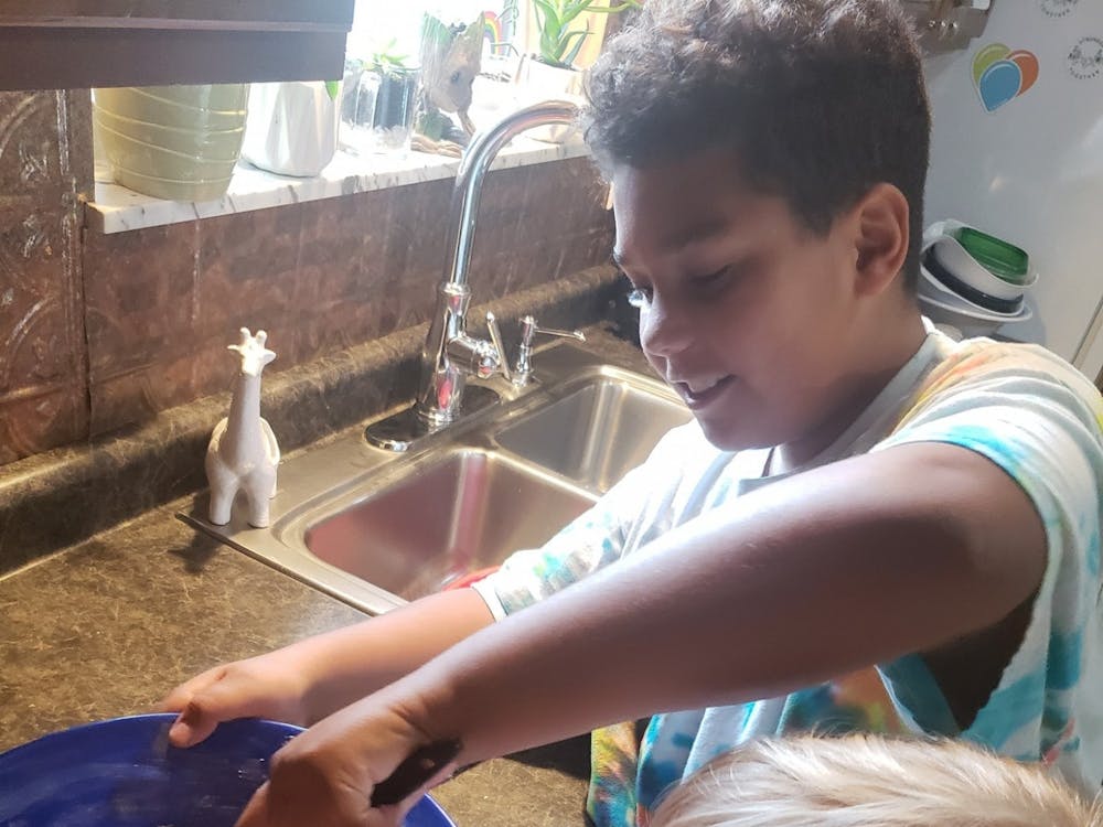 Karin Hartwell’s children, Shawn (left) and Ki (right) Hartwell help her bake this summer in their kitchen. Hartwell said Shawn and Ki only help make desserts when they're for their family, not her customers, for hygienic purposes. Karin Hartwell, Photo Provided