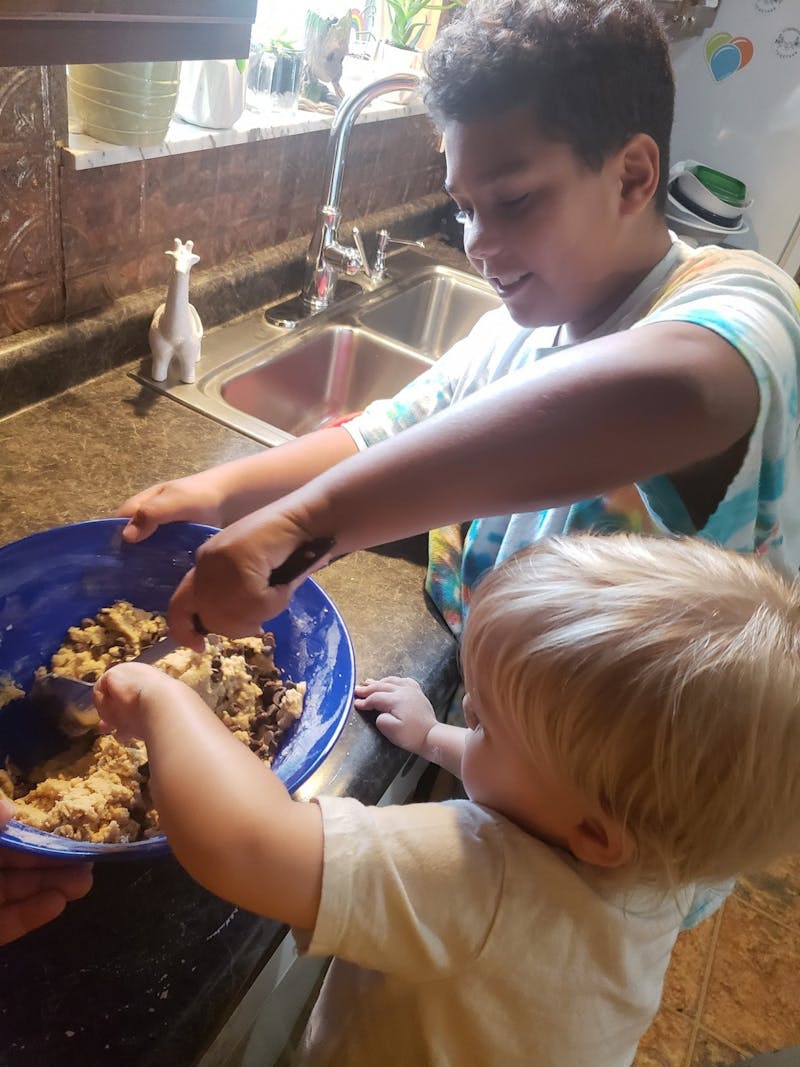 Karin Hartwell’s children, Shawn (left) and Ki (right) Hartwell help her bake this summer in their kitchen. Hartwell said Shawn and Ki only help make desserts when they're for their family, not her customers, for hygienic purposes. Karin Hartwell, Photo Provided