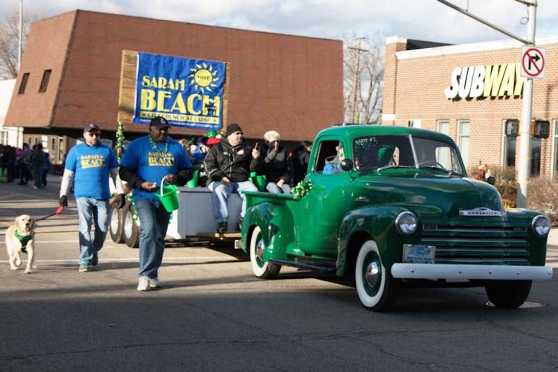 Sarah Beach, city council candidate, and her fellow attendants walk down walnut street during the St. Patrick's Day Parade March 16, 2019. All of the parade entries shared three common interests: old-fashioned vehicles, pets and the color green. Kamryn Tomlinson, DN.  