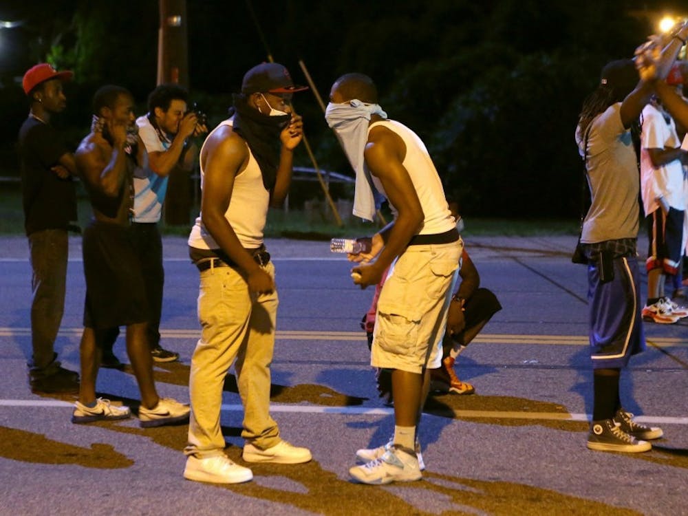 Protesters with rocks and bottles gather as they prepare to throw the items toward police on Wednesday, Aug. 13, 2014, in Ferguson, Mo. The protesters did throw the items but they fell short of police. (David Carson/St. Louis Post-Dispatch/MCT)