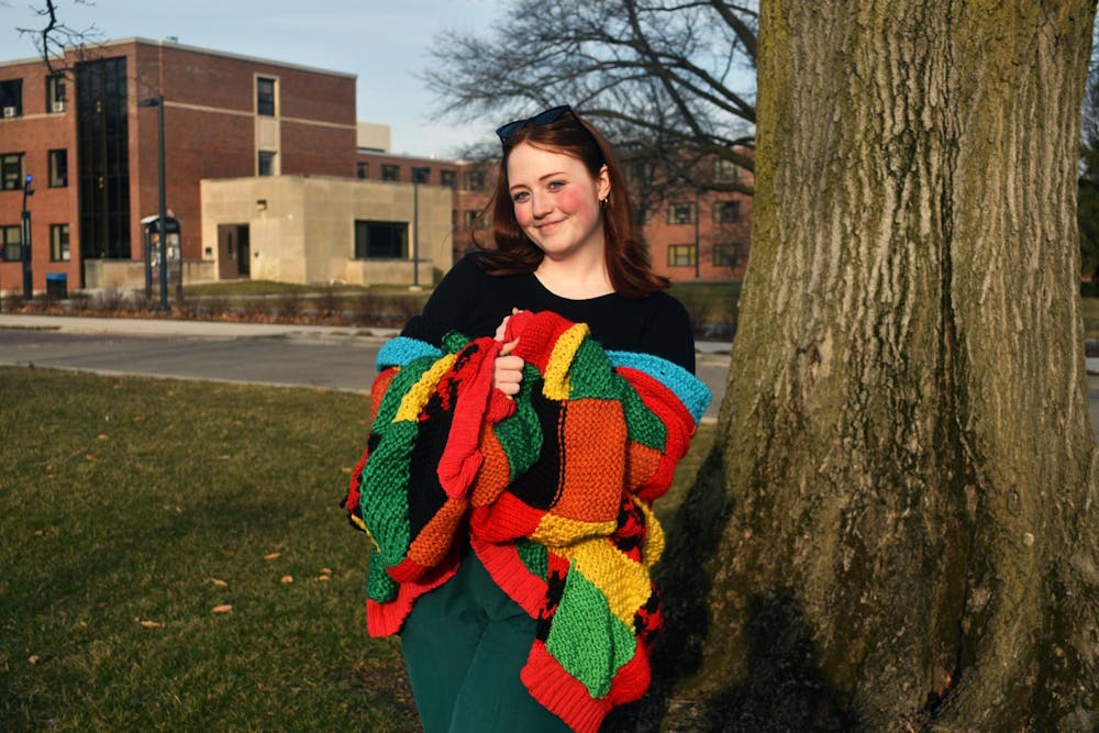 Fourth-year psychology major Stevee Judy poses with a sweater she made Feb. 26 in front of Emens Auditorium. Judy has been crocheting for over a decade. Ella Howell, DN
